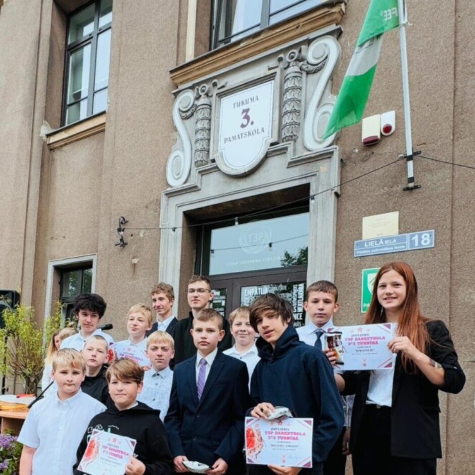 Pusaudžu grupa stāv pie Tukuma 3. pamatskolas, kuras nosaukums 